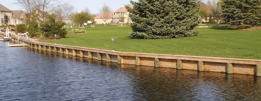 A large body of water with a wooden fence surrounding it.