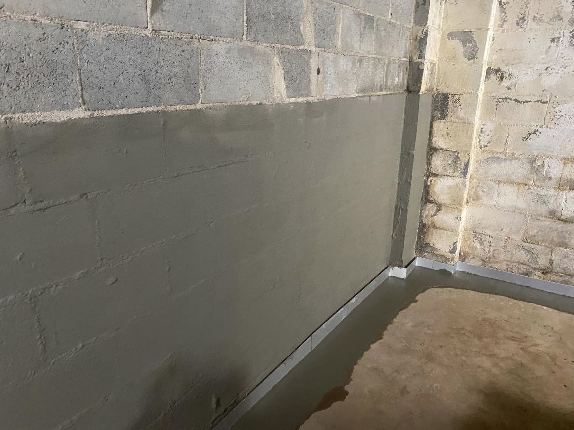 Gray coated basement walls with a concrete floor.
