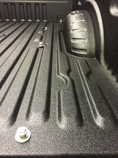 A close up of a truck bed with a screw in it.
