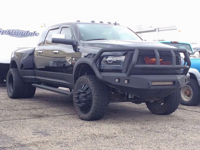 A black truck with a black bumper is parked in a parking lot.