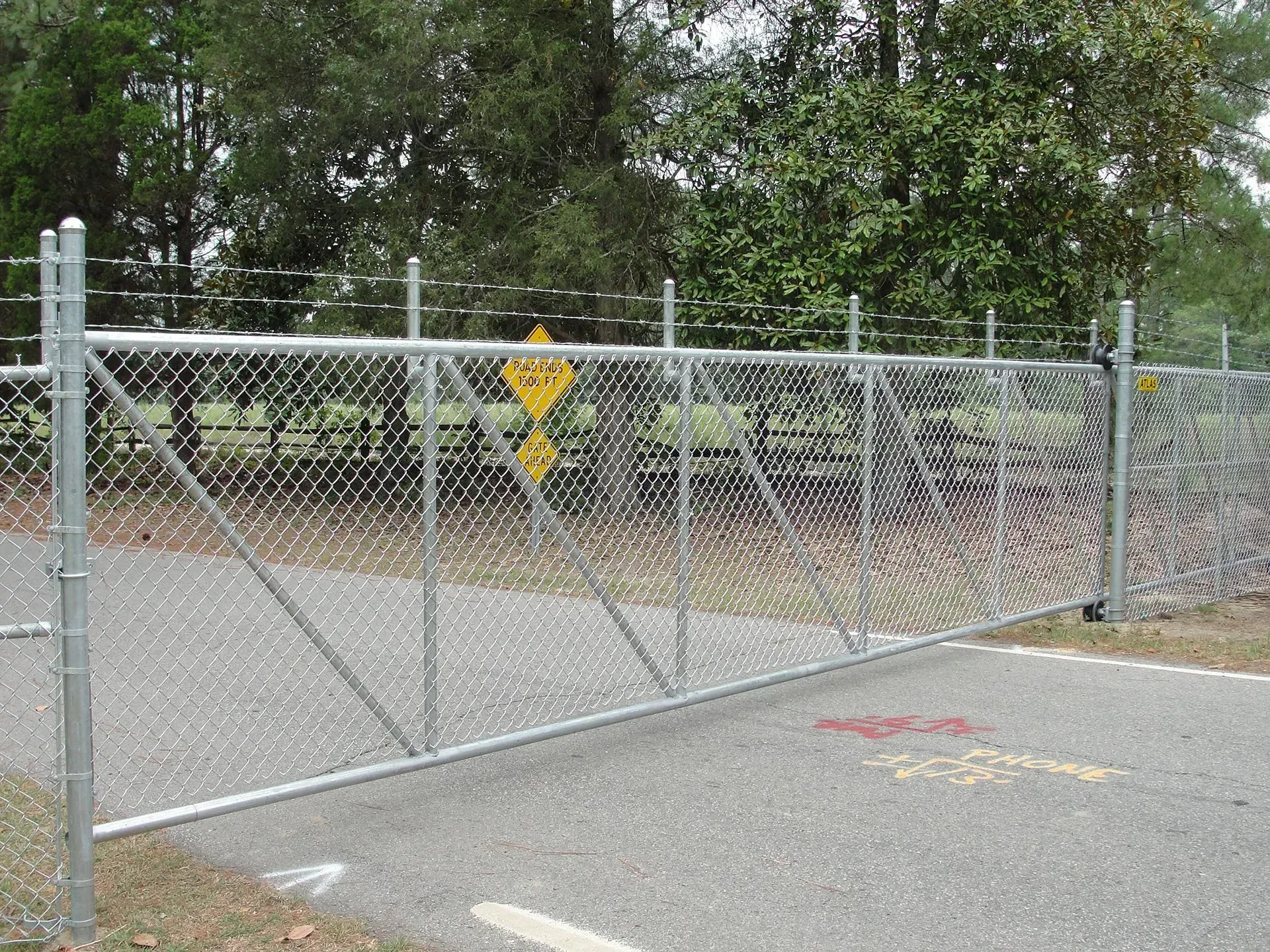 A chain link fence with a yellow sign on it