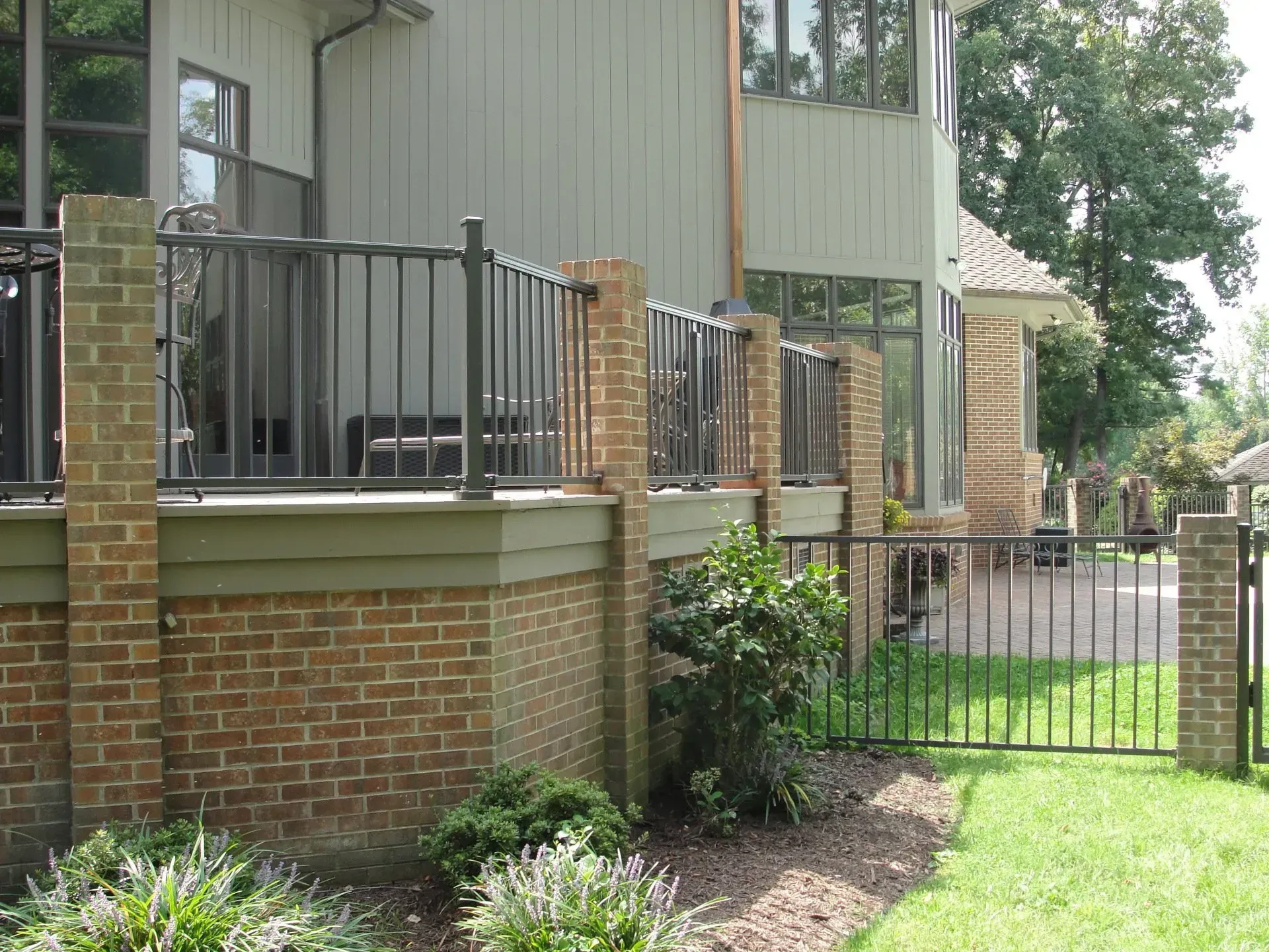 A house with a brick wall and a metal fence