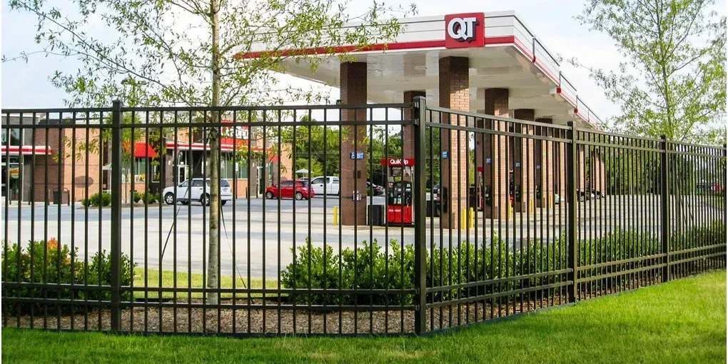 A gas station with a fence in front of it