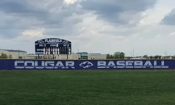 A baseball field with a sign that says cougar baseball on it.