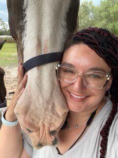 woman taking a picture together with a horse