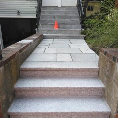 Front steps with a tiled ramp leading to a house entrance, with an orange cone on the stairs.