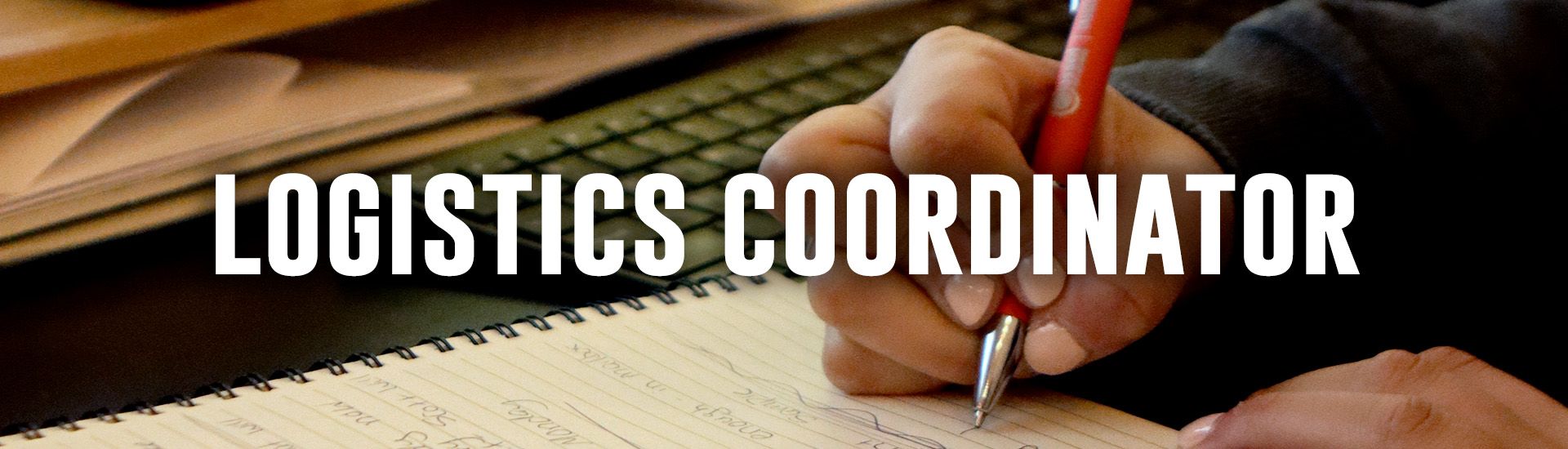 Woman seated at a desk, talking on the phone and looking at computer monitors in an office setting.