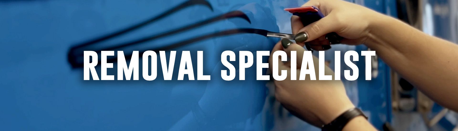 A person washes the blue exterior of a semi-truck. A Peterbilt logo is visible on the truck.