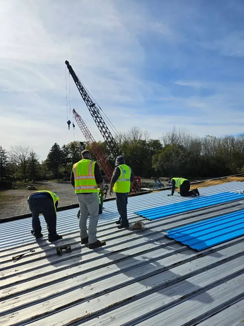 A group of construction workers are working on a roof.
