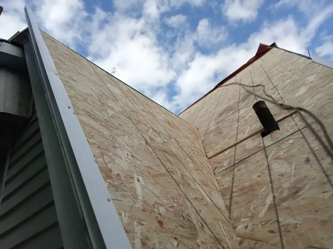 Looking up at the roof of a building with a blue sky in the background
