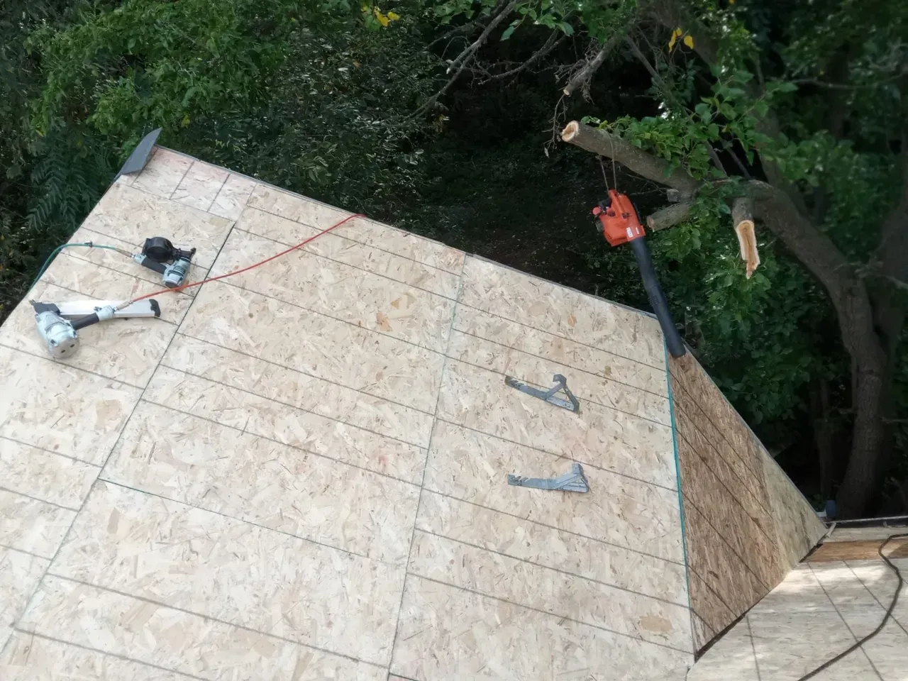 A person is working on a wooden roof with tools.