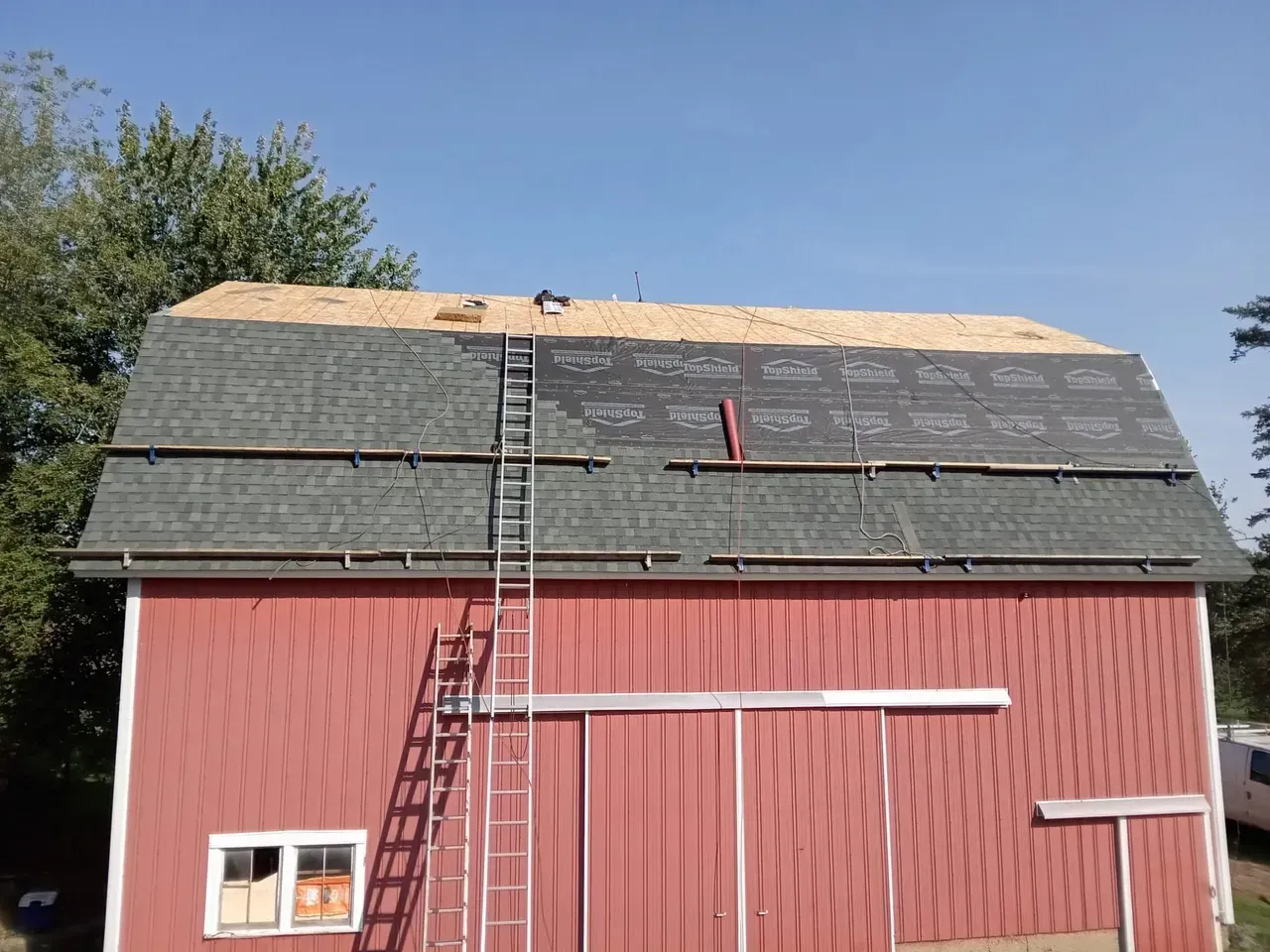 A red barn with a ladder attached to it