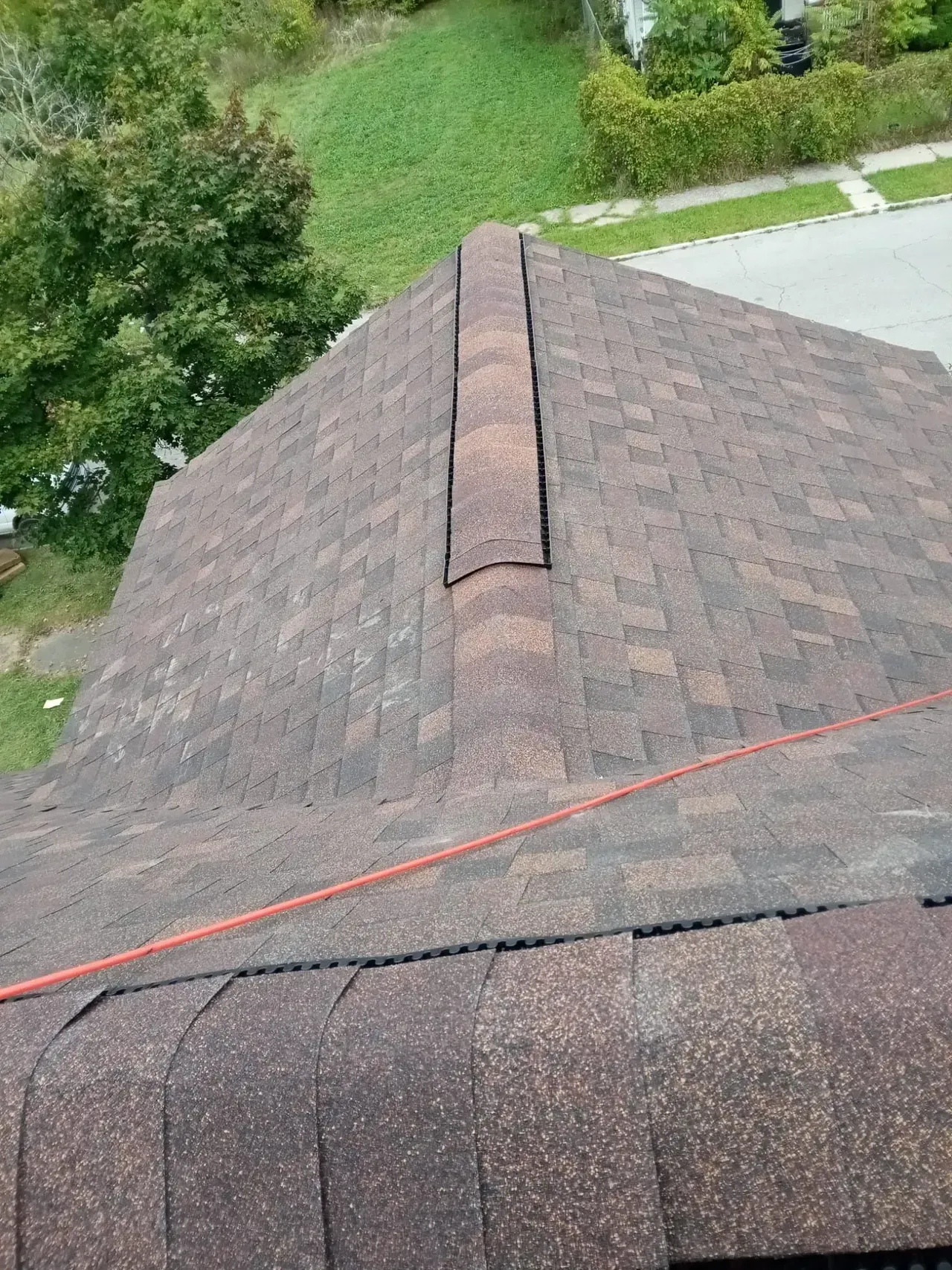 An aerial view of a roof with a red hose attached to it.