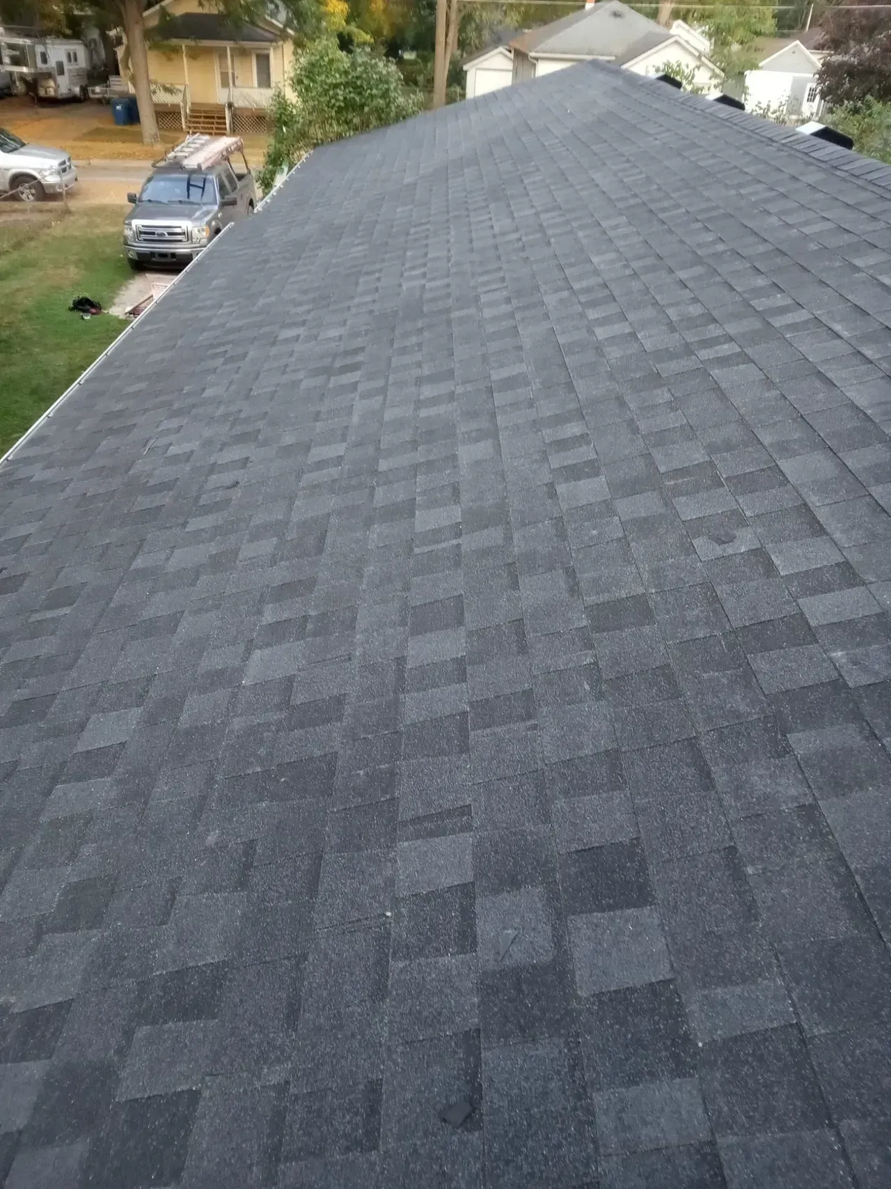 The roof of a house with a black shingle roof.