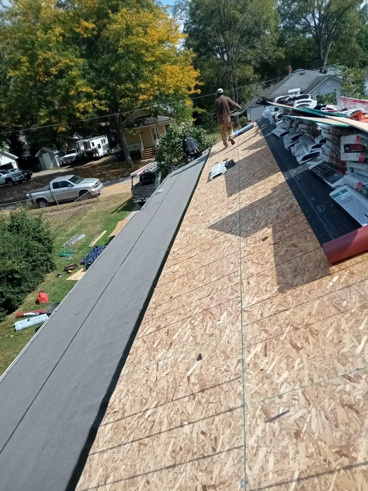 A man is standing on the roof of a house.