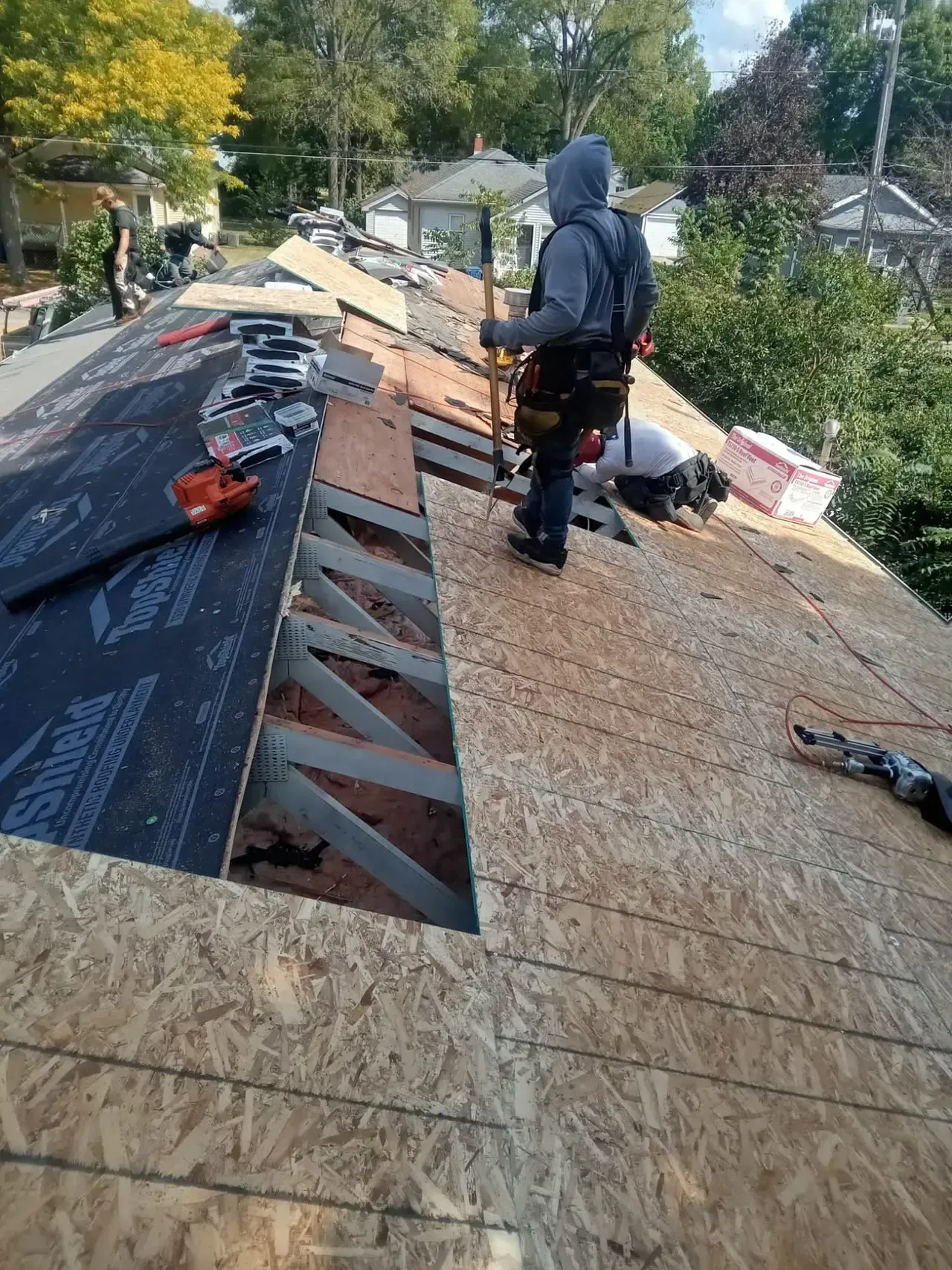 A man is working on the roof of a house.