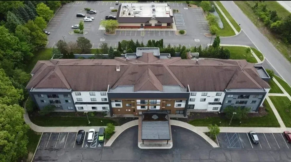 An aerial view of a large building with a parking lot in front of it