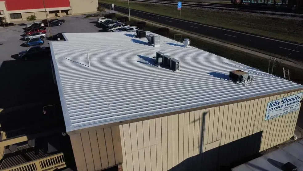An aerial view of a large building with a white roof.