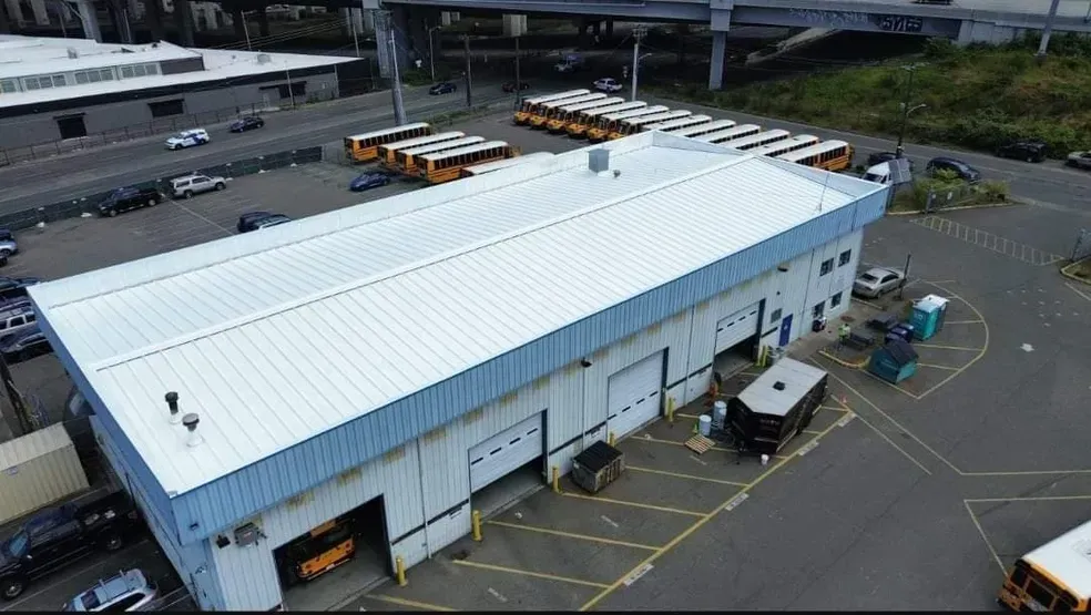 An aerial view of a building with buses parked in front of it