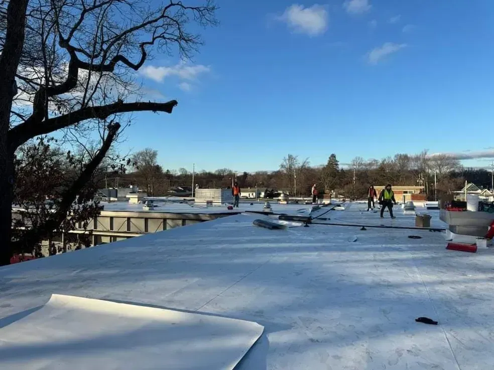 A group of people are working on the roof of a building.