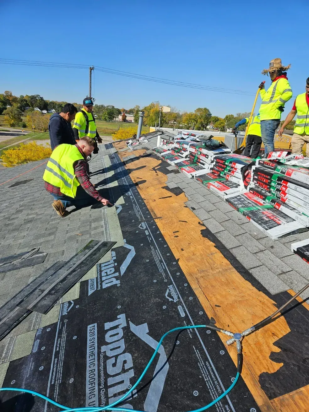 A group of construction workers are working on a roof.