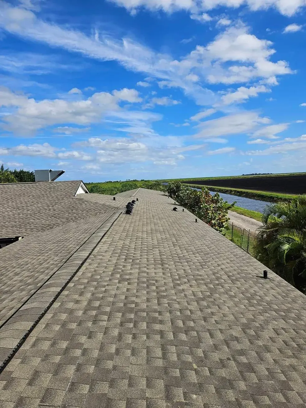 A roof with a lot of shingles on it and a river in the background.