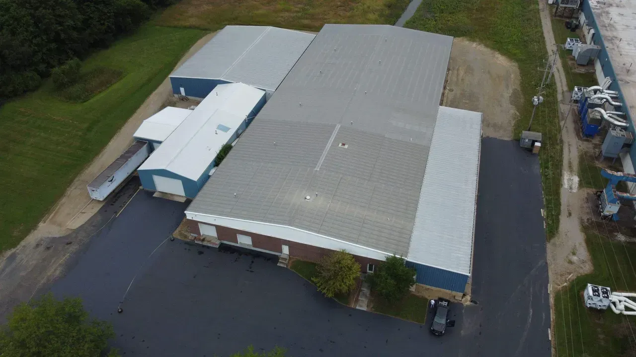 An aerial view of a large building with a car parked in front of it.