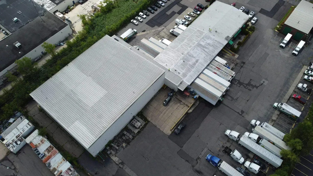 An aerial view of a warehouse with trucks parked in front of it.