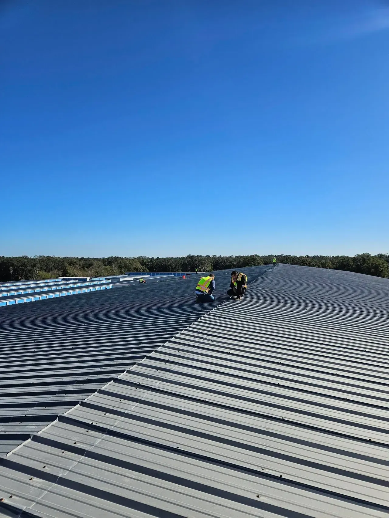 Two men are working on the roof of a building.