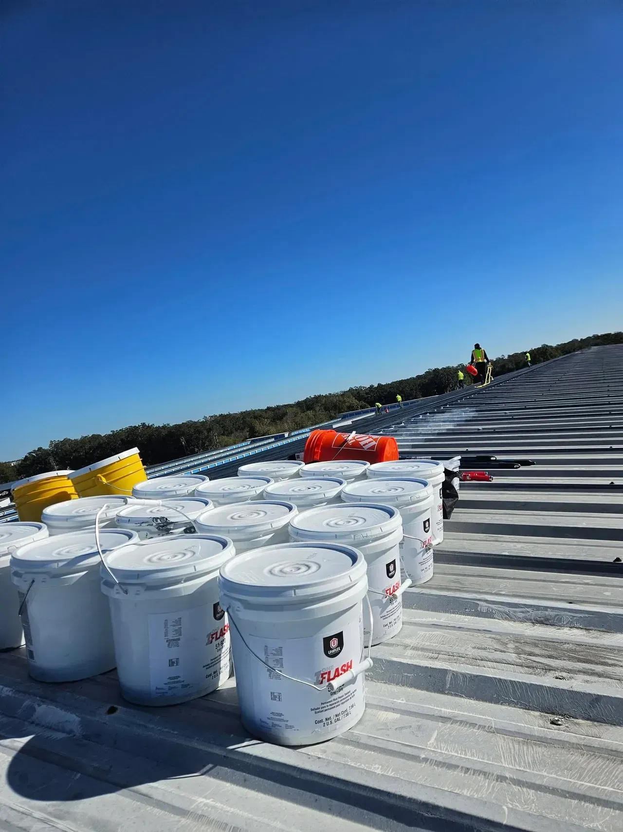 A white truck is parked in front of a large building at night.