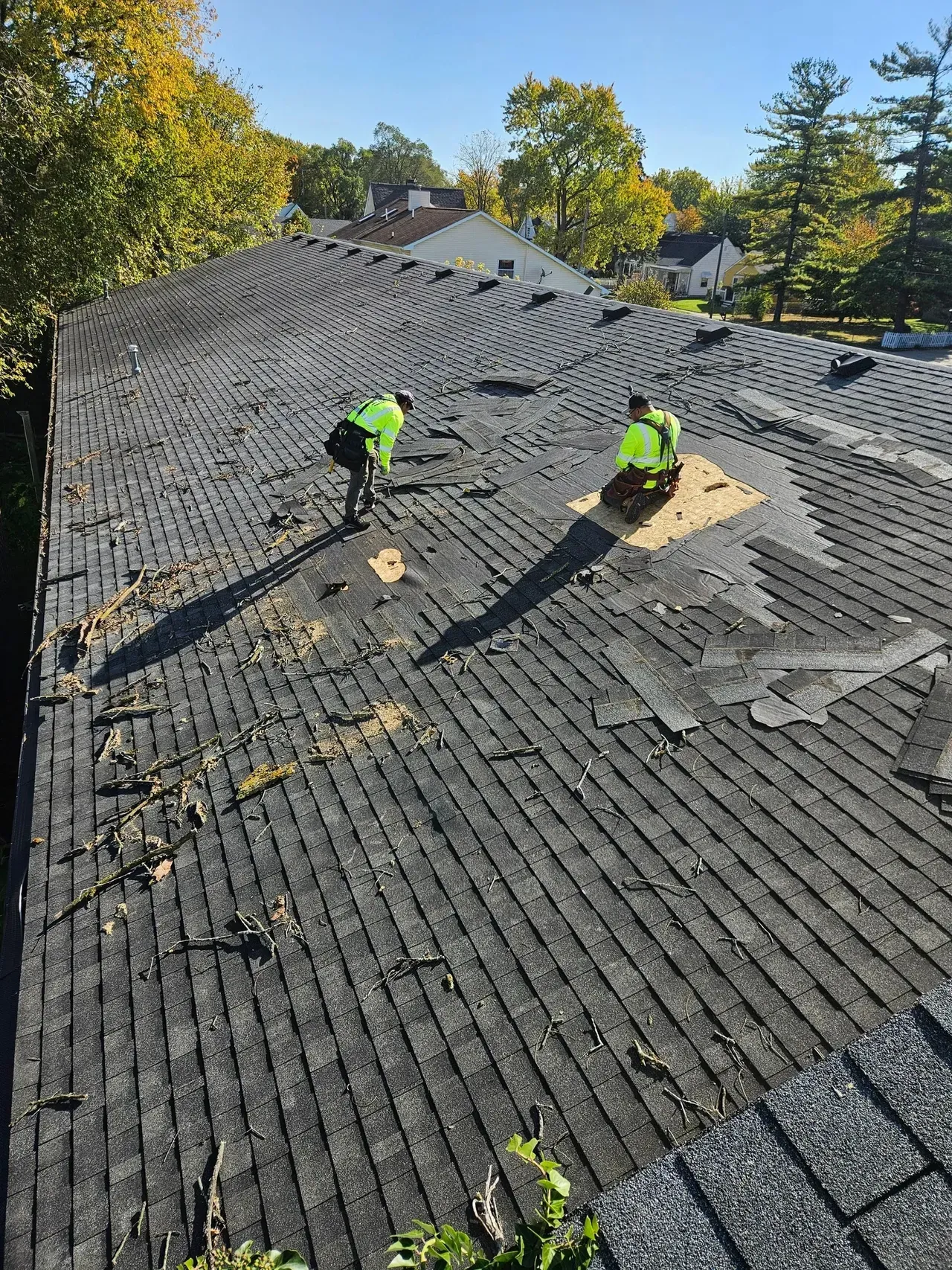 Two men are working on the roof of a house.