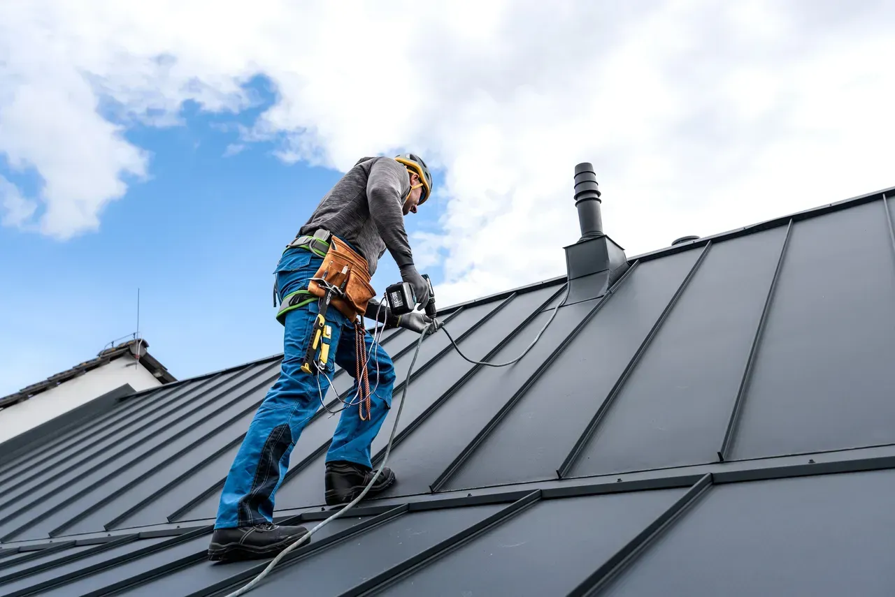 A man is working on the roof of a house