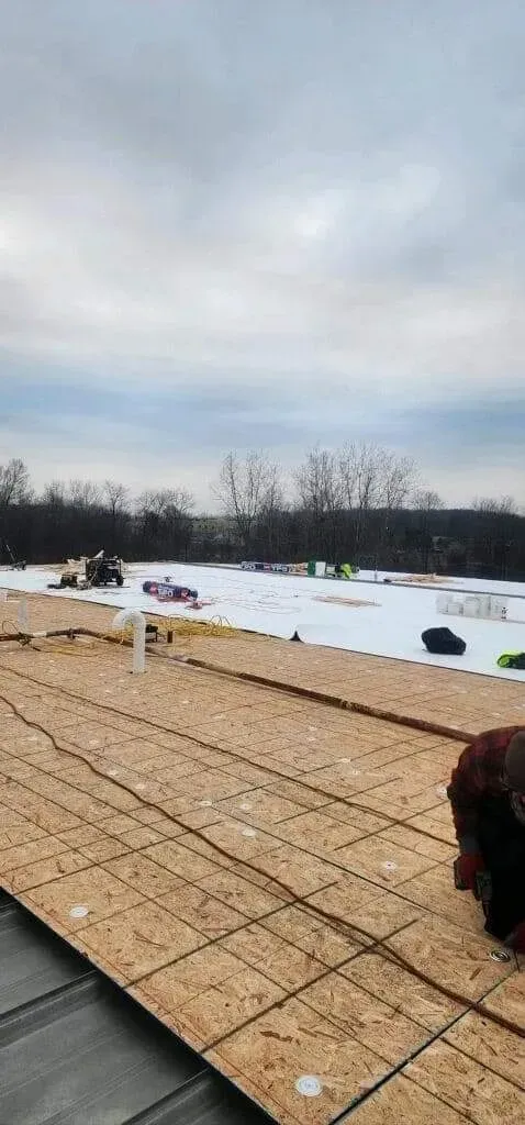 A roof is being built on top of a snow covered field.