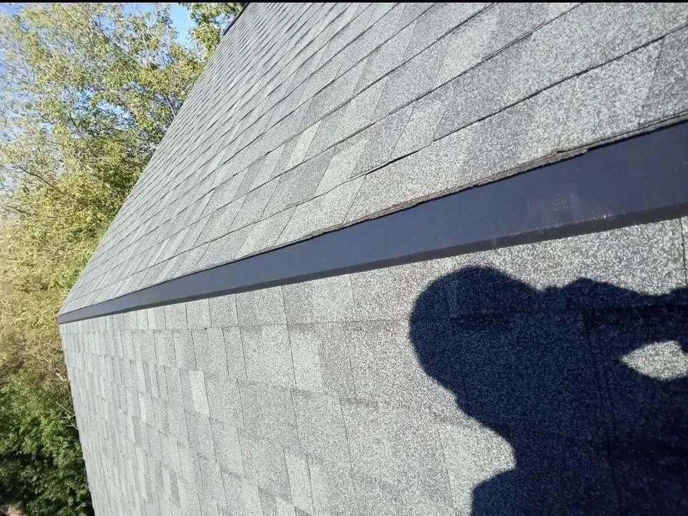 A shadow of a person is cast on the side of a building.