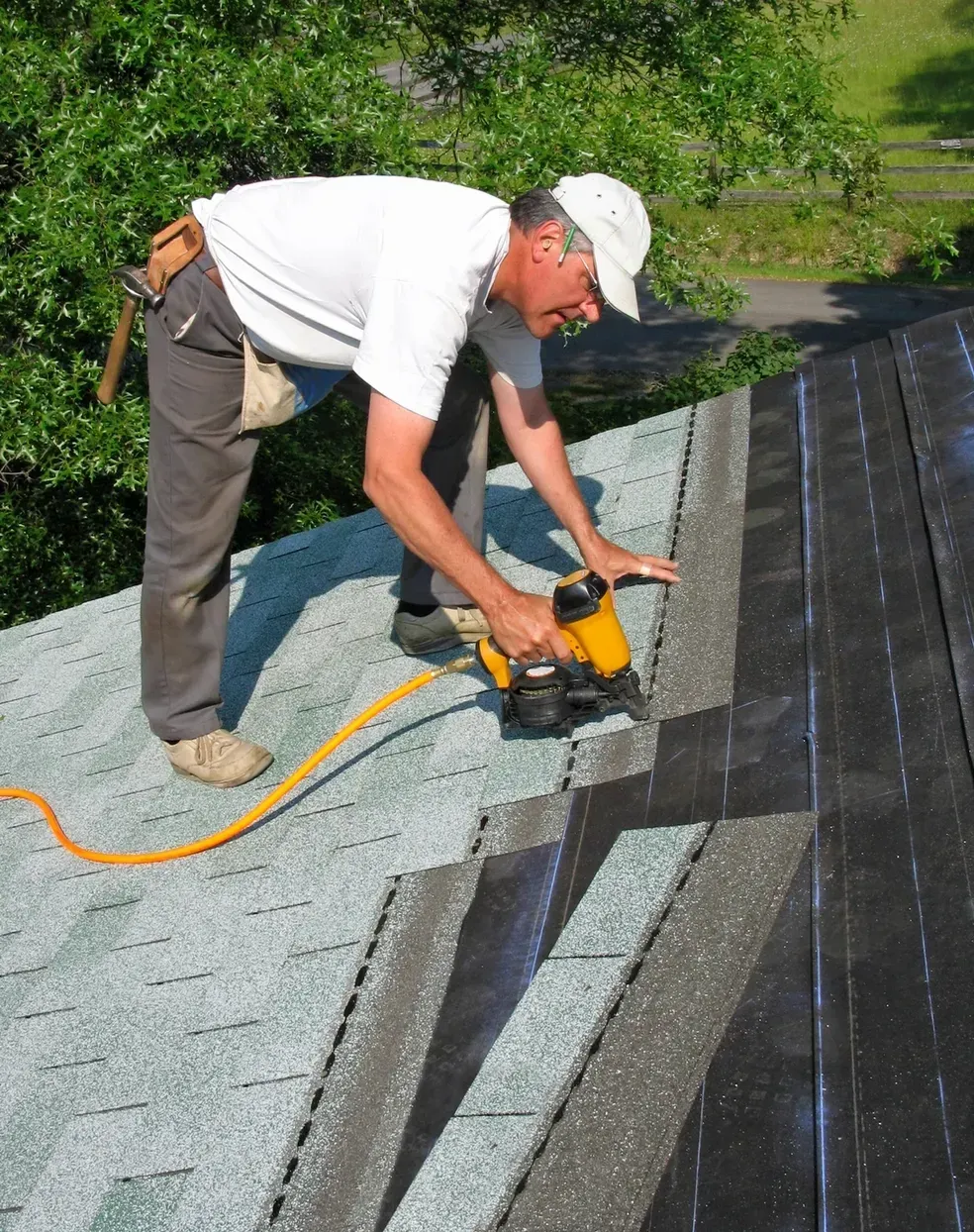 A man is installing a skylight on a roof.