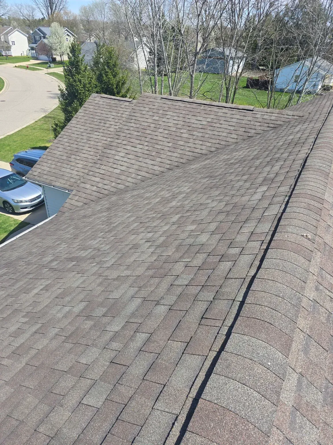 A roof with a lot of shingles and cars parked on it.