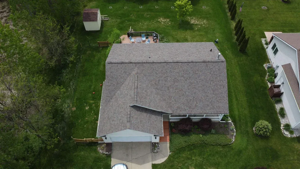 An aerial view of a house with a roof that is missing shingles.