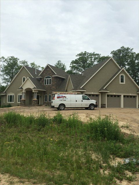 A white van is parked in front of a large house