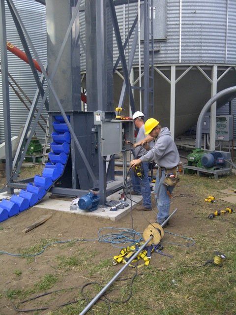 A man in a yellow hard hat is working on a machine