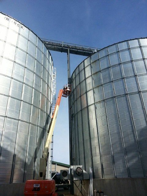 A large metal silo with a crane attached to it