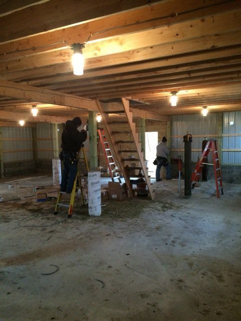 A man standing on a ladder in an empty room