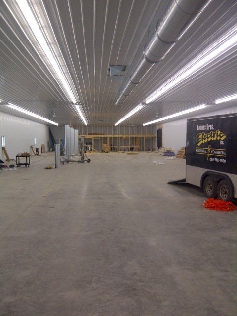 A large empty warehouse with a trailer that says ' donuts ' on it