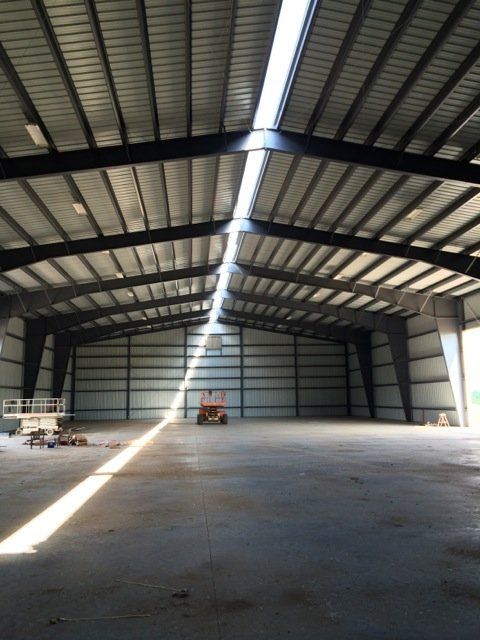A large empty warehouse with the sun shining through the windows