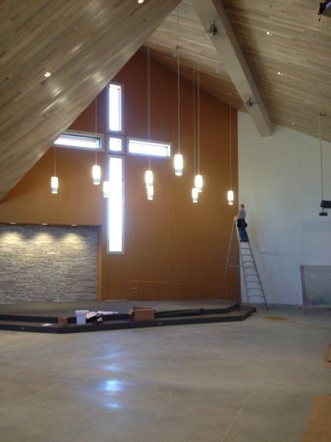 A large cross hangs from the ceiling of a church