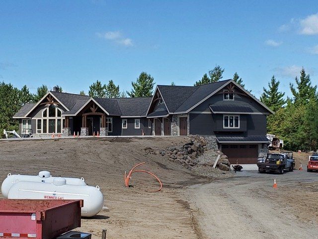 A large house is being built on top of a dirt hill