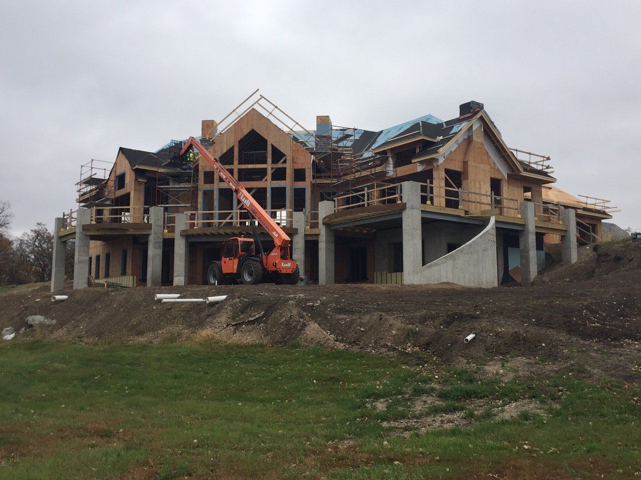 A large house under construction with a crane in front of it