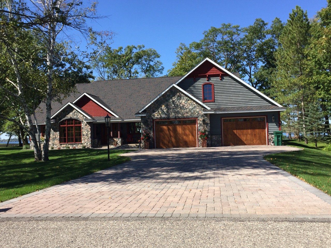 A large house with two garages and a driveway in front of it.