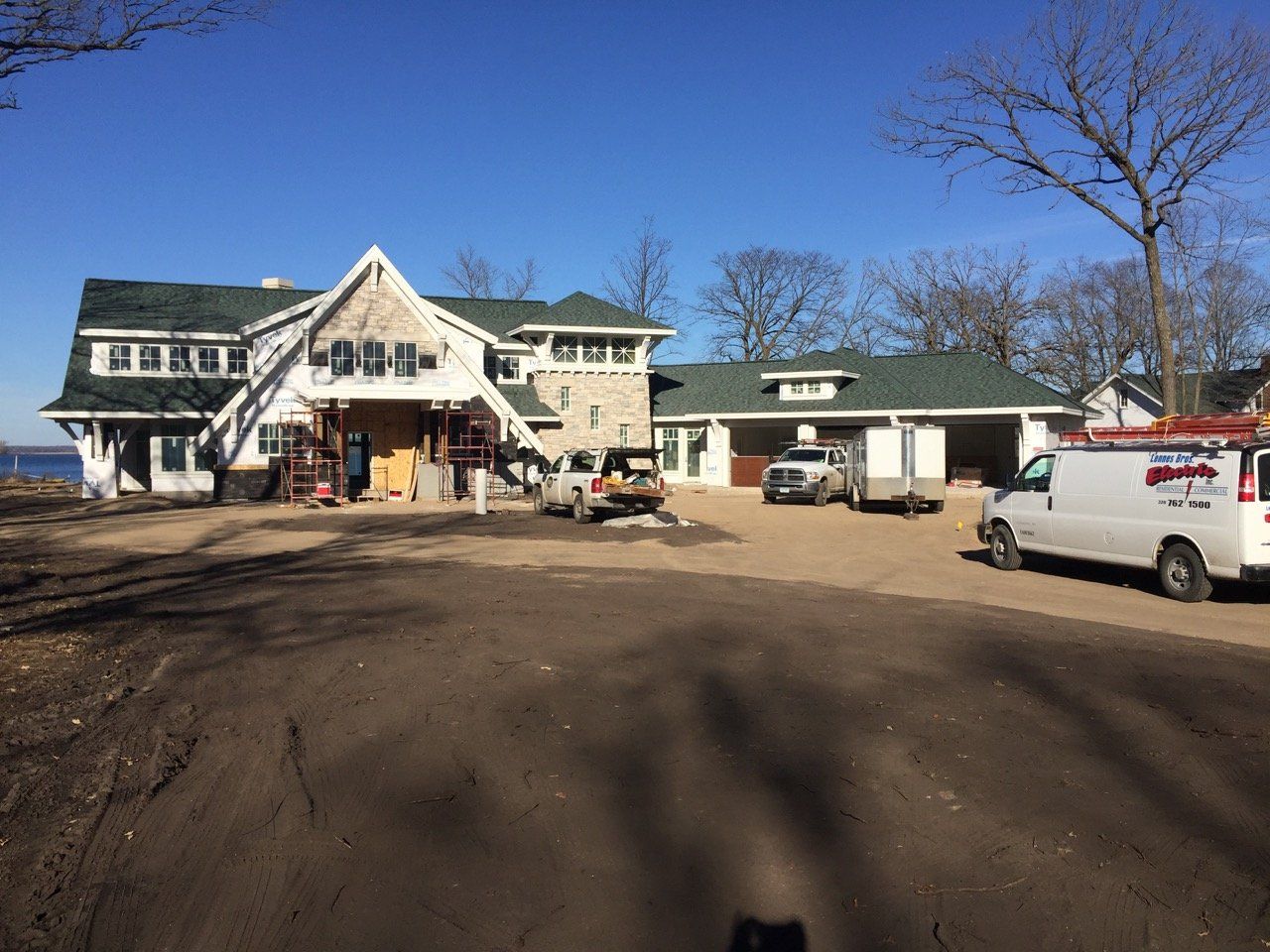 A large white house with a green roof is being built.