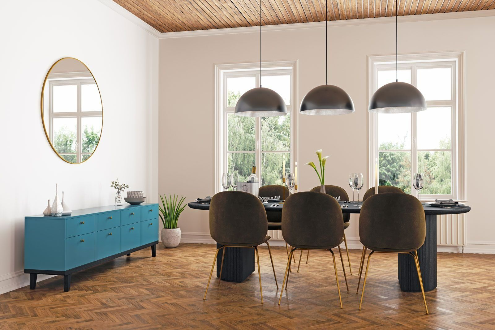 A modern dining room with a blue credenza, a black oval table with velvet chairs, and three pendant lights.