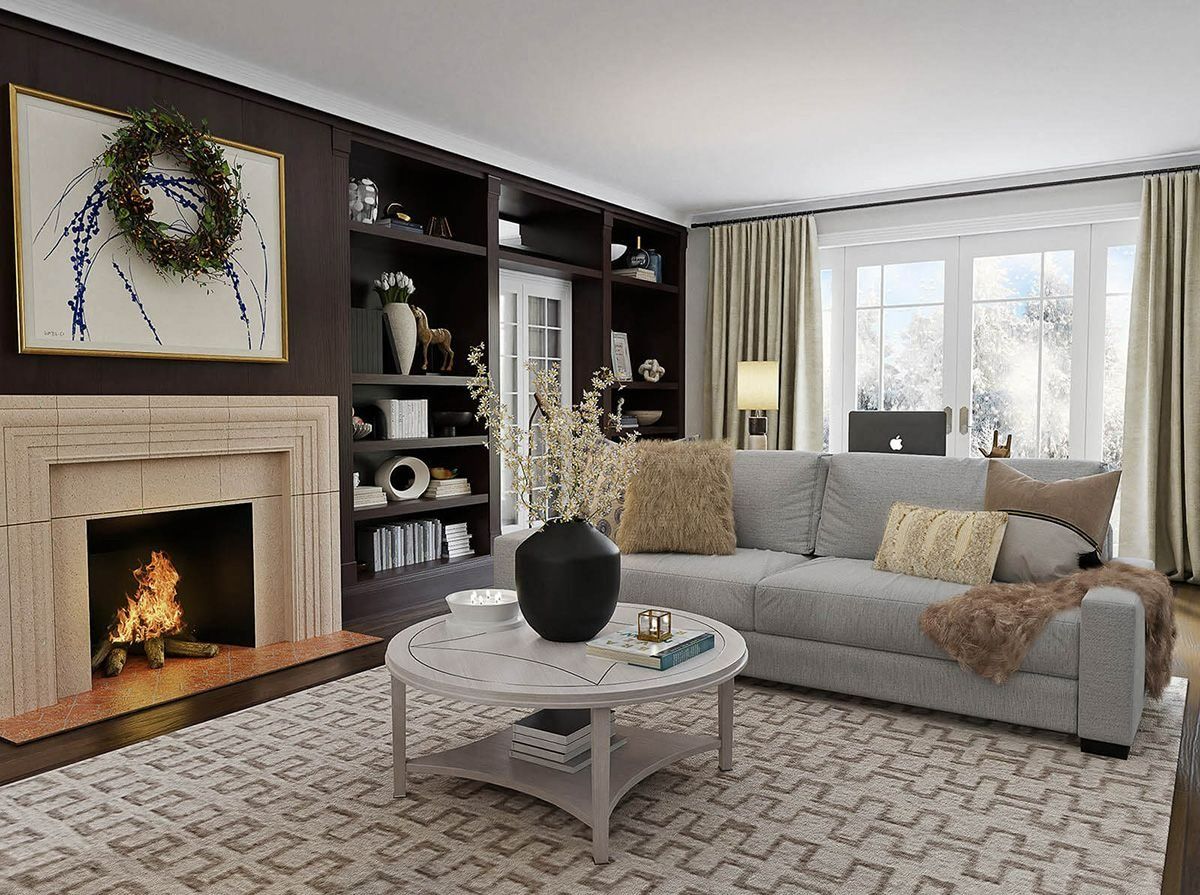 A cozy living room with a stone fireplace, dark bookshelves, a grey sofa, and a round coffee table on a patterned rug.